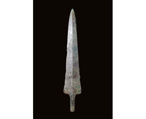 Ca. 2nd - 1st millennium BC.A cast bronze spearhead featuring a triangular-shaped blade with a sharp, pointed tip. The promin