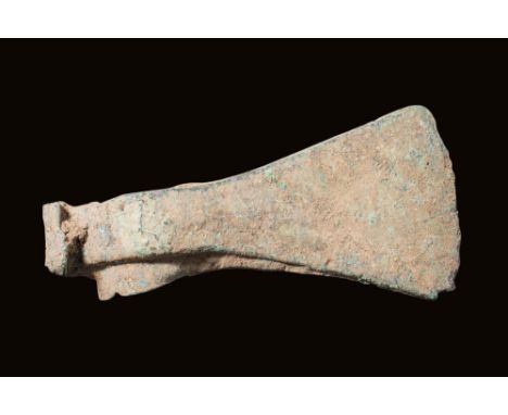 Ca. 2nd - 1st millennium BC.A bronze axe head with a tubular shaft and a long flaring blade. Bronze axes were essential tools