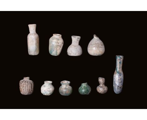 Ca. AD 1 - 400.A group comprising 10 glass containers, displaying various shapes and styles. Among them are bulbous flasks, b