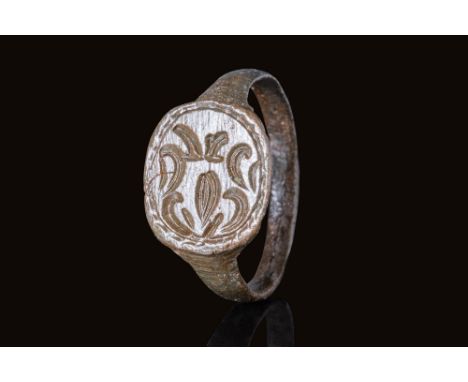 Ca. AD 1200 - 1400.A bronze ring constructed with a flat-section slender hoop that gradually expands to form a large, flat ov