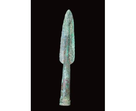 Ca. 400 - 300 BC.A cast bronze spearhead featuring a leaf-shaped blade with a pronounced midrib and a tubular, slightly flari