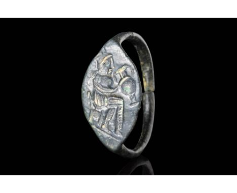 Ca. 400 - 300 BC.A bronze ring with a round hoop flat-section connected to an almond-shaped bezel engraved with a central ima