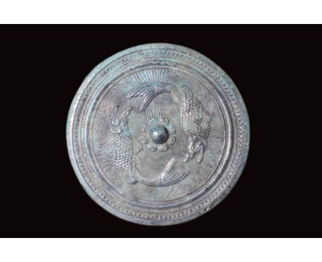 Ca. AD 618 - 907 or later.A round-shaped bronze mirror with a pierced central knob. The flat underside, left unadorned, was p