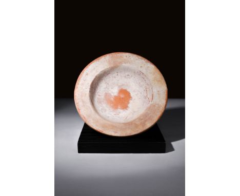 Ca. AD 100 - 300.A redware plate with a rounded basin and a ring foot. The dish features a broad flange around its edge. The 