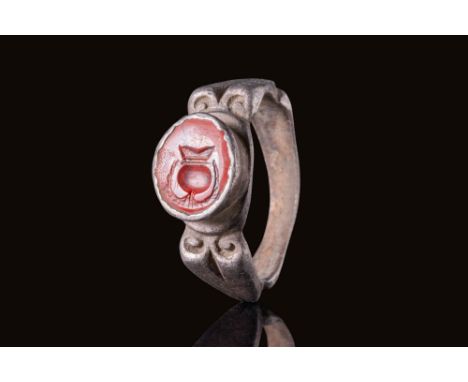 Ca. AD 300.A silver ring featuring an ornate hoop with a carinated back section. Volutes are present where the carinated back