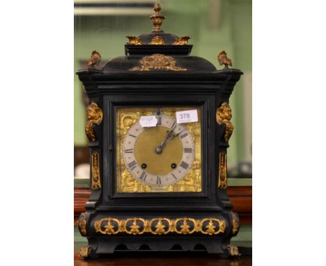 An ebonised striking table clock with applied gilt metal mount