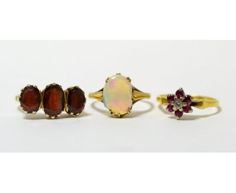 A 9ct gold garnet ring, an 18ct gold ruby and diamond cluster ring and an opal ring (a.f.)9ct gold garnet ring - finger size 