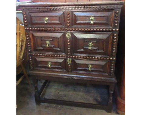 A 17th century style oak moulded front and bobbin moulded chest, of three long drawers, raised on a stand, width 33ins x dept