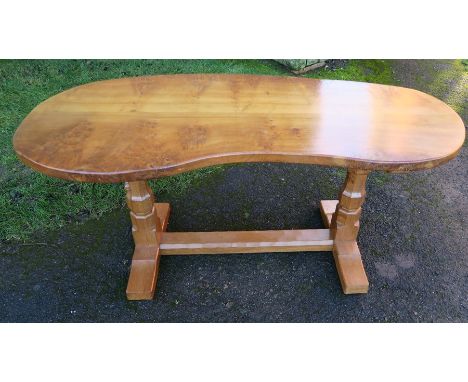 A Robert Mouseman Thompson burr oak kidney shaped table, raised on octagonal supports, 65ins x 31ins, height 29.5ins