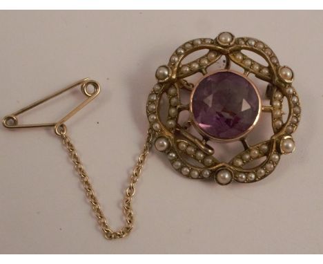 An Edwardian amethyst and seed pearl brooch, with a safety chain, 2.3cm diameter, stamped '9ct', 4.8g gross