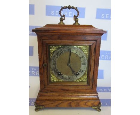 An oak cased&nbsp; mantle clock, the square dial with silvered chapter ring, the striking movement stamped W and H, height 11