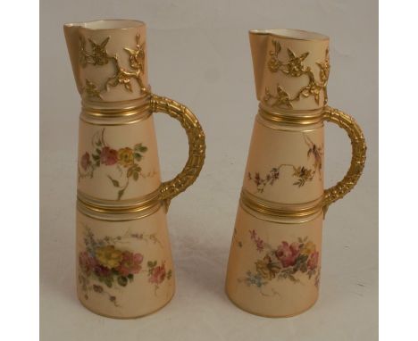Two Royal Worcester blush ivory claret jugs, decorated with floral sprays, with gilt bands and handle, shape number 1047, af,