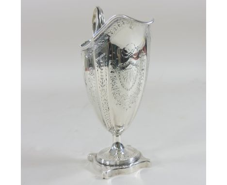 A George III silver helmet shaped cream jug, engraved with floral swags, London 1787, 16cm tall