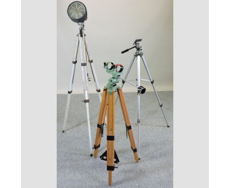 An industrial style light, on a tripod base, together with a camera tripod and another
