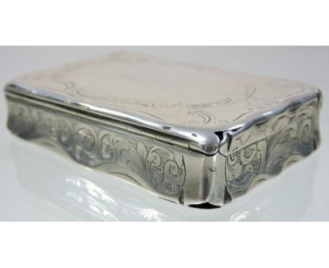 A George III silver snuff box, of hinged rectangular shape, with scrolled foliate engraved decoration, inscribed indistinctly