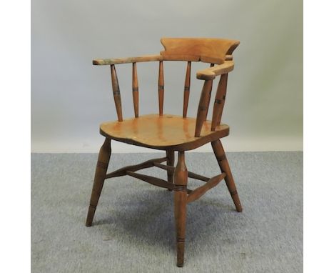 An early 20th century light oak smoker's chair 