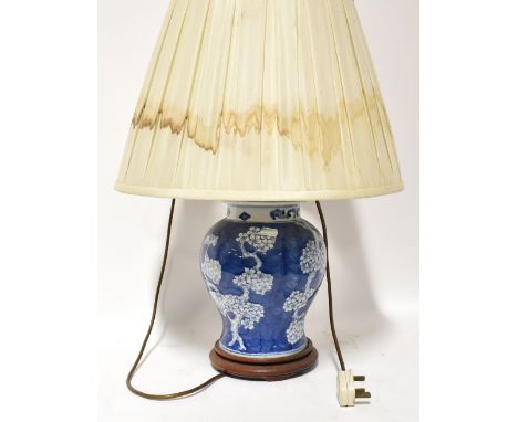 A Chinese porcelain table lamp in the form of a covered ginger jar, hand painted in blue and white with cherry blossom decora