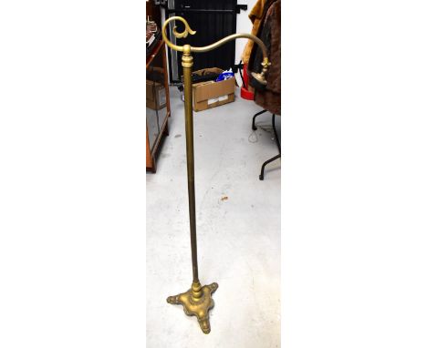 An early 20th century brass standard lamp with scrolling top arm above fixed brass tube, the base with a knopped stem and tri