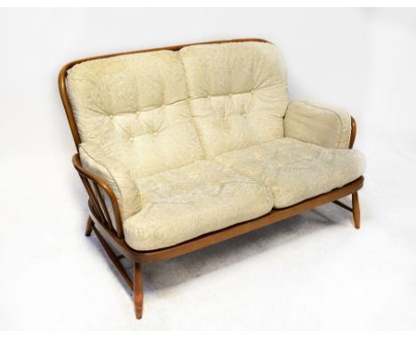 ERCOL; a Jubilee two-seater stick back settee, raised on turned cross-stretchered supports.