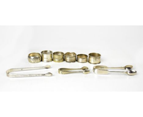 Two pairs of hallmarked silver sugar tongs, together with five various silver napkin rings, two plain and three with engraved