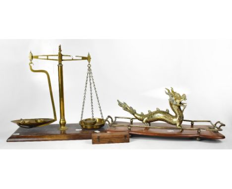 A set of brass scales on mahogany rectangular plinth, with a quantity of weights (some weights missing), an Edwardian inlaid 