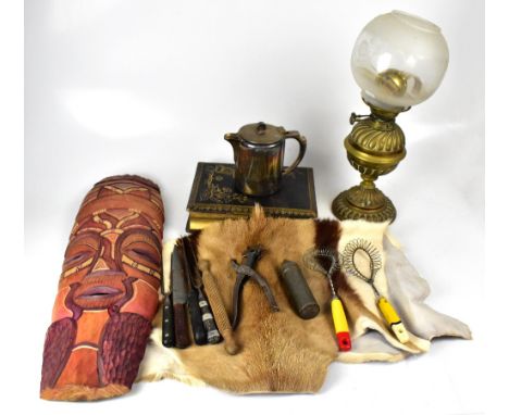 A collectors' lot comprising goat skins, a Victorian musical photograph album, carved wooden mask, a cuckoo clock, various so