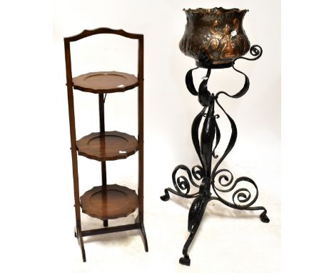 A copper planter in the Arts &amp; Crafts style, on a black wrought iron stand, to tripartite support and an Edwardian mahoga