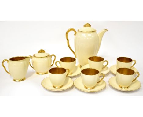 CARLTON WARE; an early/mid-20th century coffee set in pale buttermilk, with gilded interiors and gilt-heightened rims, handle