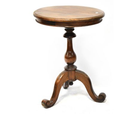 A reproduction mahogany circular occasional table on turned baluster column, to three outswept scrolling supports with carved