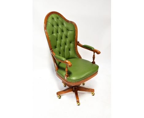A contemporary green leather button back studded yew wood framed open arm revolving office chair, raised on five outswept sup