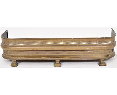 An Edwardian brass fender with fretwork detail, supported on bracket feet. H=21, L=90, W=25cm