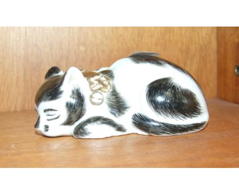 A ceramic model of a sleeping cat, 12cm long.