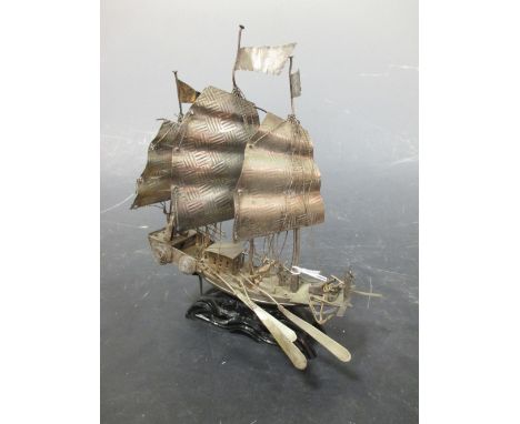 A Chinese 'silver' marked model sailing junk on wood stand  Oars a bit bent  Looks like some minor bits are missing  Need sor