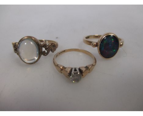 A 9ct gold ring rub over set with an oval opal triplet, a 9ct gold ring rub over set with an oval moonstone and a 9ct gold si