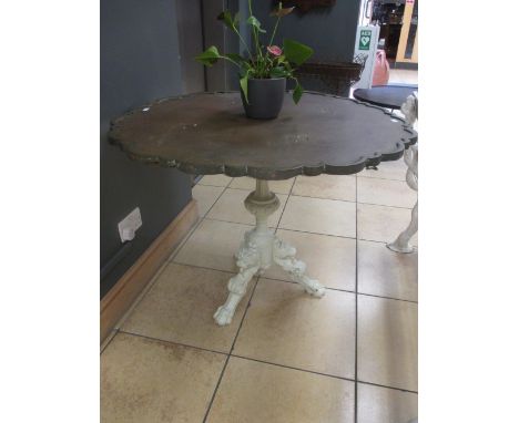 A large brass top pedestal table, the shaped circular top on an associated later painted carved wood tripod base with lion pa