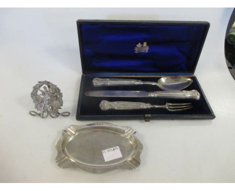 An oval silver ashtray Birmingham 1923, a William IV silver christening fork, knife and spoon set with filled handles, engrav