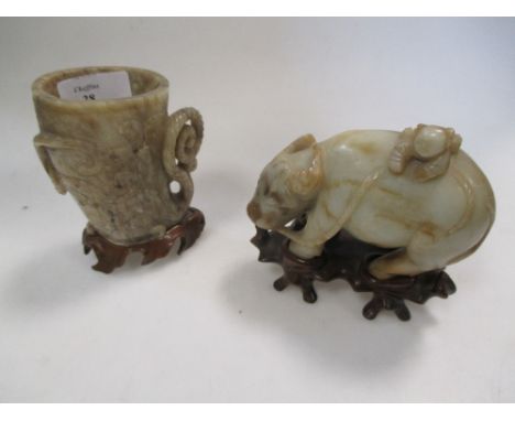 A 19th century Chinese jade boy on a buffalo, a jade libation cup and wood stands  