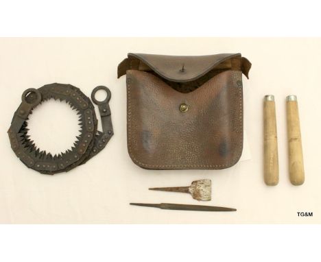 A WW2 coil saw in its leather pouch complete with handles and tools. The pouch marked with the War Department crows foot and 