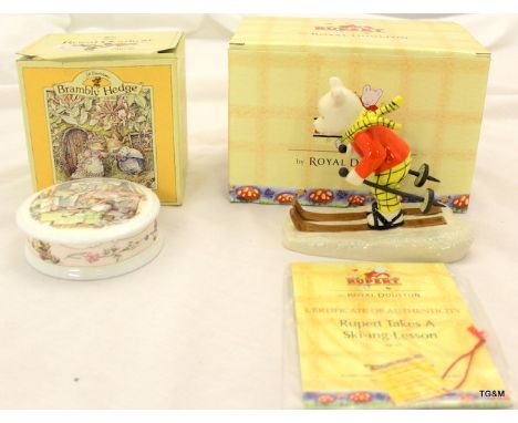 A Royal Doulton Rupert Bear taking a skiing lesson figure and a Royal Doulton Brambly Hedge Trinket box