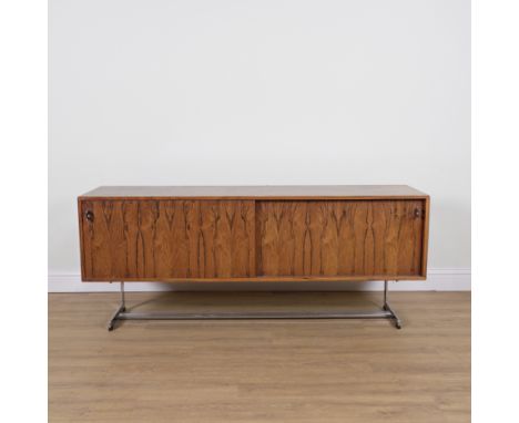 PROBABLY MERROW ASSOCIATES; A MID-20TH CENTURY ROSEWOOD SIDE CABINETWith duel sliding doors over chrome supports, 183cm wide;