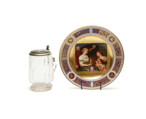 A GERMAN GLASS LIDDED TANKARD (2)Late 19th century
The hinged metal cover inset with a porcelain panel painted with a girl wr