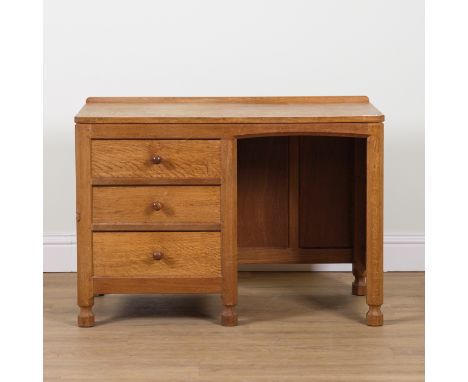 ROBERT MOUSEMAN THOMPSON OF KILBURN; AN OAK ADZED TOPPED KNEEHOLE WRITING DESKWith three pedestal drawers on octagonal suppor