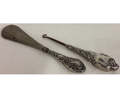 A 20th Century silver handled shoe horn together with a silver handled button hook. Est. £20 - £30.
