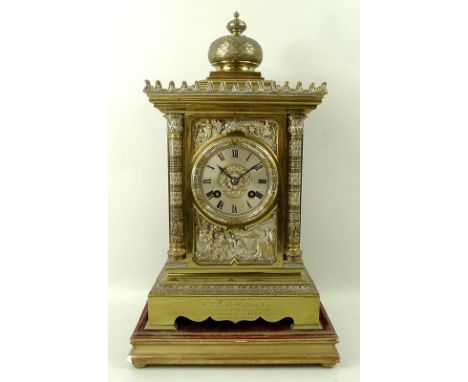A late Victorian Indian brass mantel clock, the silvered dial with Roman numerals, eight day twin train movement chiming on a
