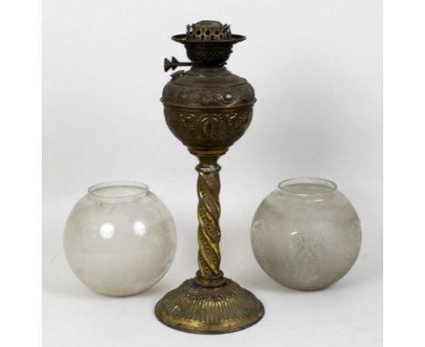 A Victorian brass oil lamp, with spiral stem and embossed well, on round base, 6cm, and two etched clear glass globes. (3)