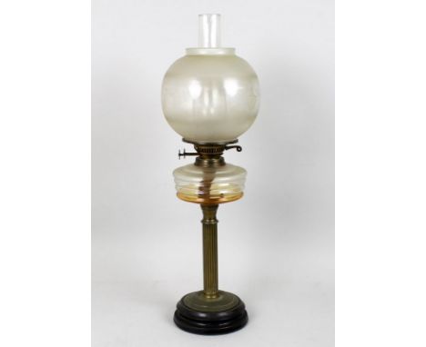 A paraffin lamp with turned slate base, fluted column, clear glass reservoir, and an etched shade, 66cm. 