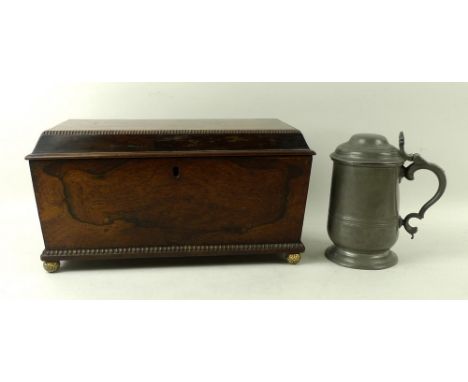 A rosewood sarcophagus tea caddy, with two lions head and ring handles, on four ball feet, with fitted interior for two compa