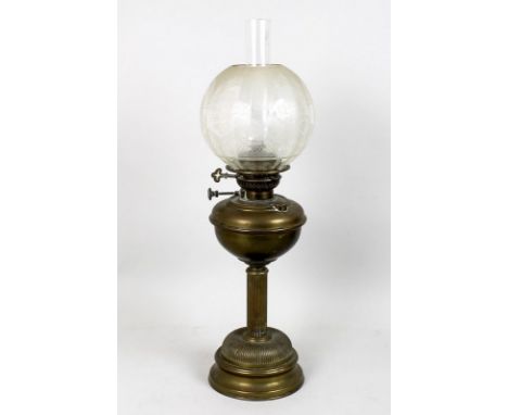 A brass oil lamp with clear etched glass shade, the reeded column over half reeded base, 67cm. 