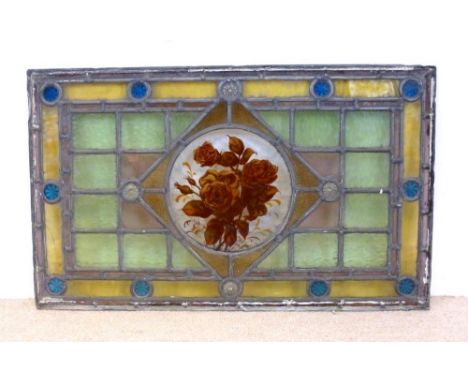 A panel of Victorian leaded, stained and painted glass, the central clear glass roundel painted with roses, inset to a diamon