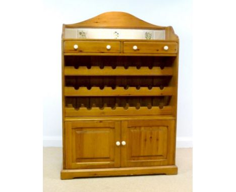 A modern pine kitchen storage stand / cupboard, with shaped, tiled back, above two drawers, three bottle racks and a double f